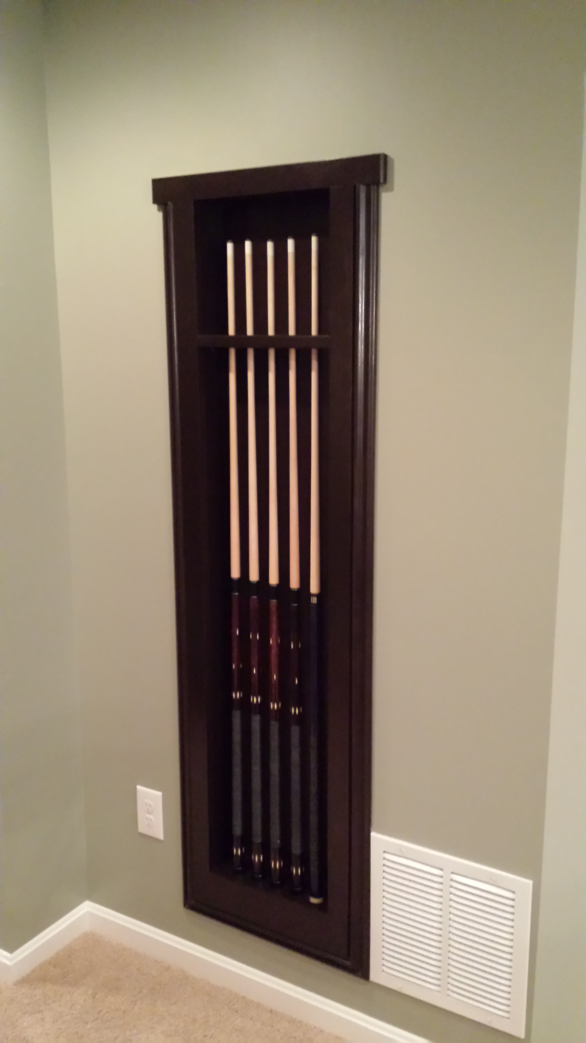 Cue holder mounted on basement wall